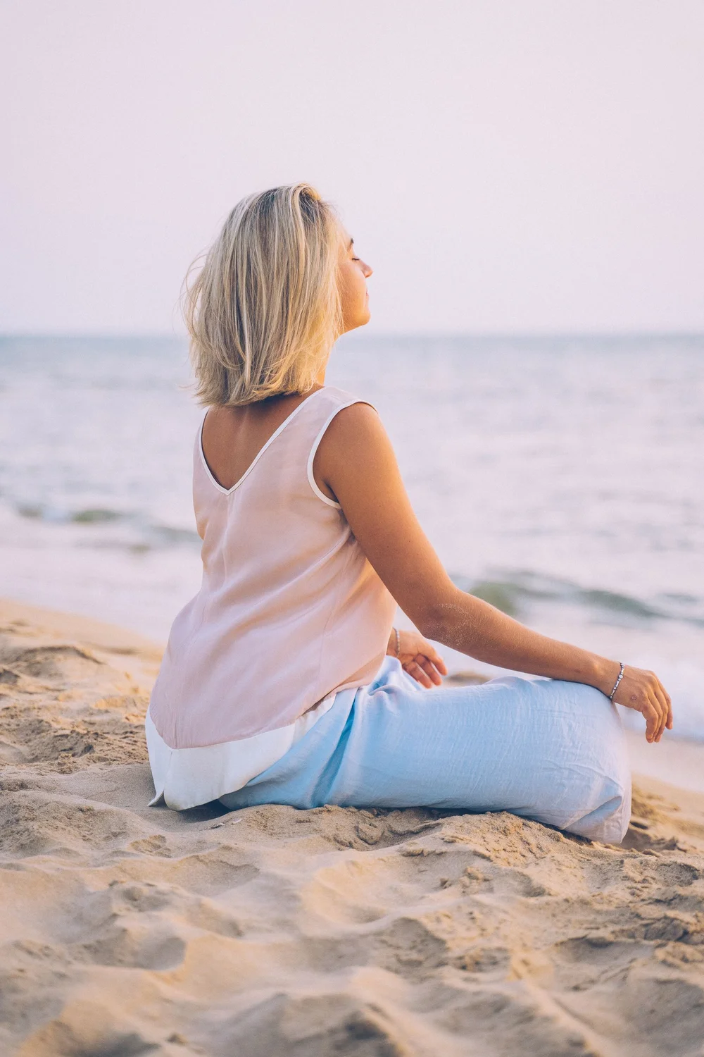 A woman sitting by the sea