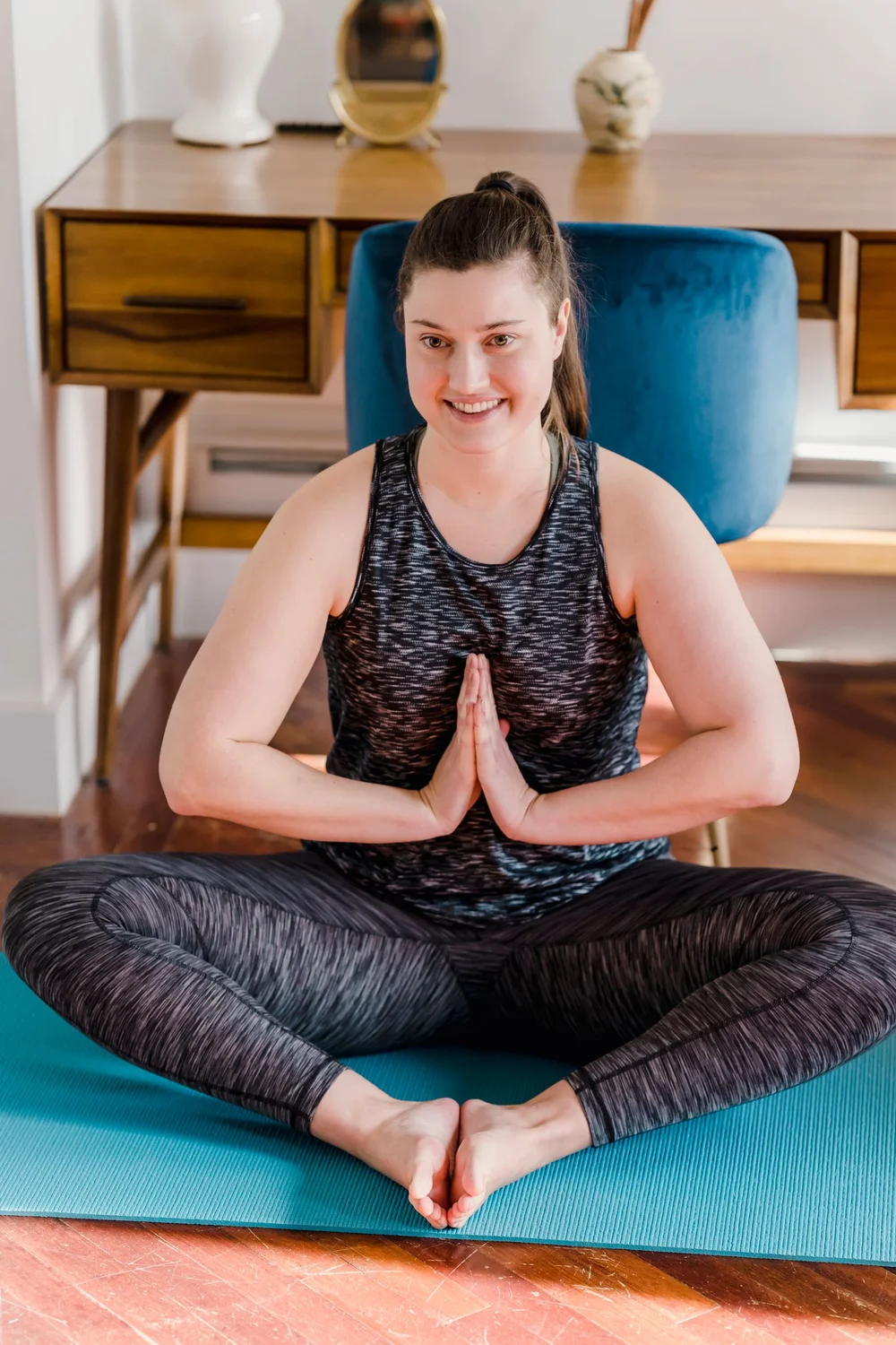 A smiling yoga practitioner sitting on a mat